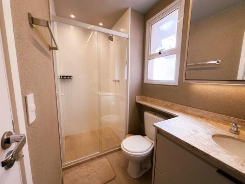 a bathroom with a shower and a toilet and a sink at Loft Prime Ribeirão Apogeo in Ribeirão Preto