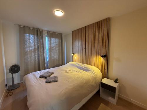 a bedroom with a white bed with a window at Le Cocon du Bord de Loire ! Appartement spacieux pour 6 personnes avec terrasse & parking in Nantes