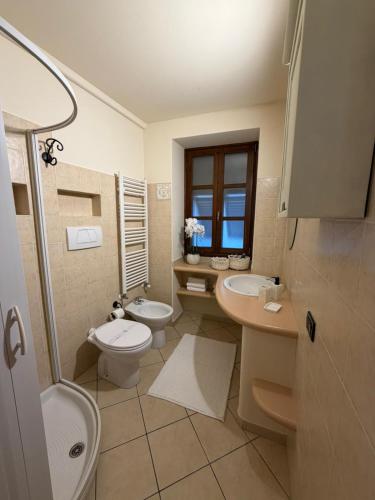 a bathroom with two sinks and a toilet and a shower at Casa Dani - terrazza relax, parcheggio gratuito e comfort a due passi da Oneglia in Imperia