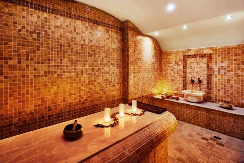 a bathroom with a marble counter top and wooden floors at Lucky Bansko Aparthotel SPA & Relax in Bansko