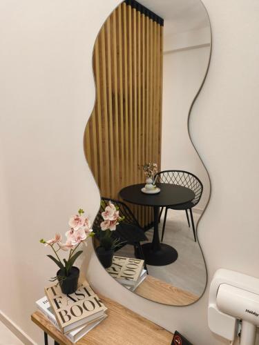 a mirror on a wall with a table and a chair at Lounetta Apartments 1 in Missolonghi