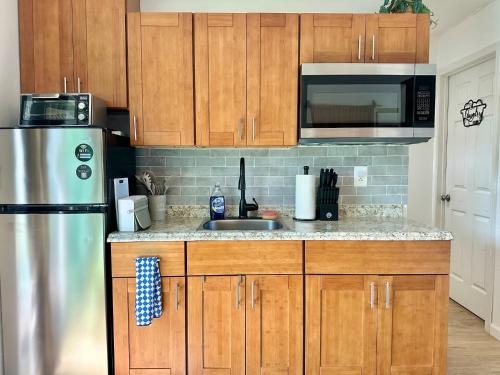 a kitchen with wooden cabinets and a stainless steel refrigerator at Happy Hill Inn in Kailua-Kona