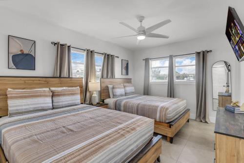 a bedroom with two beds and a ceiling fan at Bayview Regency Apartments By Lowkl in Fort Lauderdale