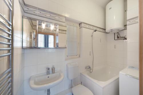 La salle de bains blanche est pourvue de toilettes et d'un lavabo. dans l'établissement Old Town Melantrichova Apartment, à Prague