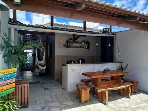 a patio with a wooden table and benches at Casa de veraneio - FA Beach in Conde