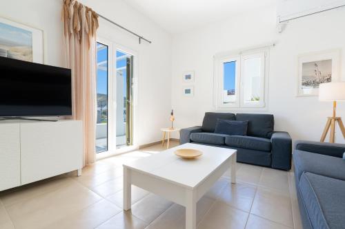 a living room with a couch and a tv and a table at Summer Villa in Adamantas