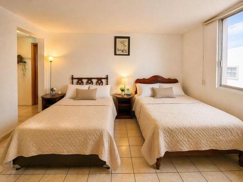 a hotel room with two beds and a window at Loft Maria in Tlazcalancingo
