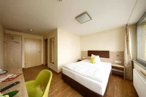 a hotel room with a bed and a table at Hotel-Restaurant Römerhof Superior in Herrenberg