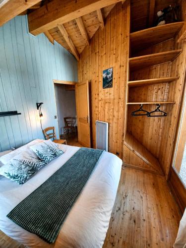 a bedroom with a bed in a room with wooden walls at Villa Silote in La Grave
