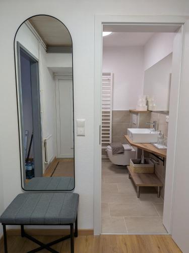 a bathroom with a mirror and a bench and a sink at Lindo - Historisches Hof-Juwel in Schützen am Gebirge