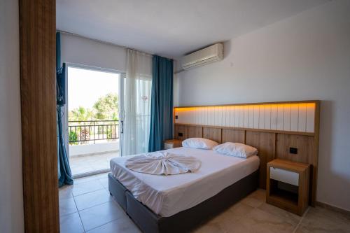 a bedroom with a bed and a large window at Tunan Motel in Ayvalık