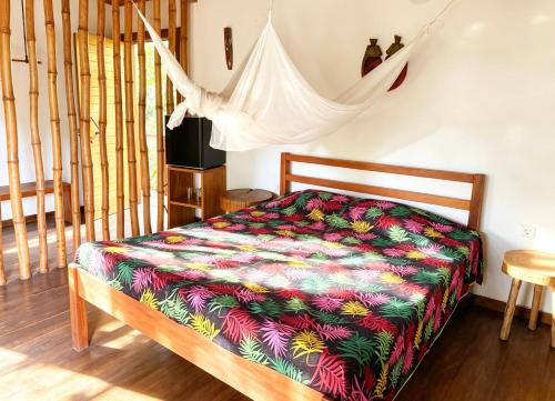 a bedroom with a bed with a colorful comforter at ECO-POR in Rio do Ouro