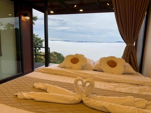 two swans made out of towels laying on two beds at Heaven Khaokho2 in Khao Kho