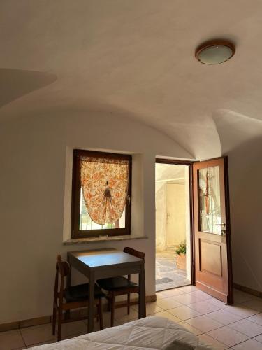 a dining room with a table and a window at Lûc Dal Aur in Sùtrio