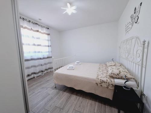 a white bedroom with a bed and a mirror at Apartment Sia in Jadranovo