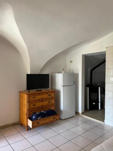 a kitchen with a refrigerator and a television on a dresser at Lûc Dal Aur in Sùtrio