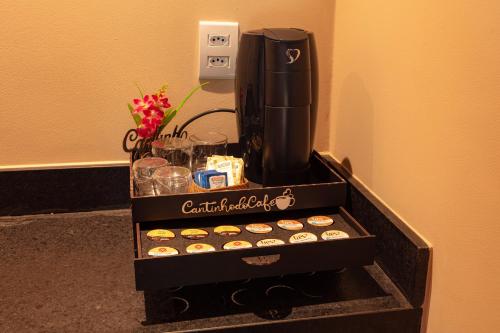 a coffeemaker with cupcakes and a coffee maker at Hotel Ilha do Marajó by Unna in Soure