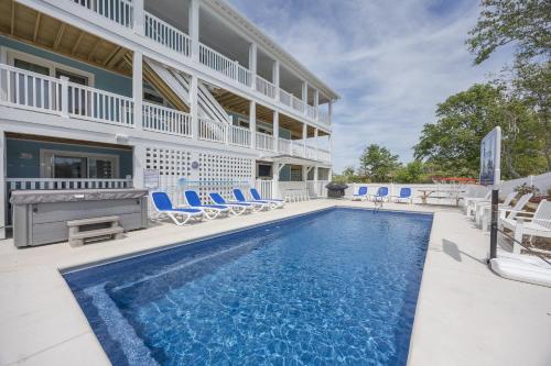 a swimming pool in front of a building with blue chairs at 2934 - Seas the Day in Duck