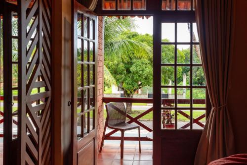 an open door to a room with a chair on a porch at Hotel Ilha do Marajó by Unna in Soure