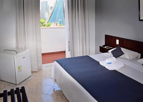 ein Schlafzimmer mit einem großen Bett, auf dem Handtücher liegen in der Unterkunft Hotel Carioca in Rio de Janeiro