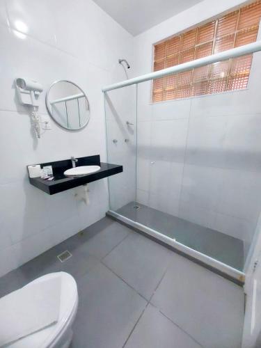 ein Badezimmer mit Dusche, Toilette und Spiegel in der Unterkunft Hotel Carioca in Rio de Janeiro