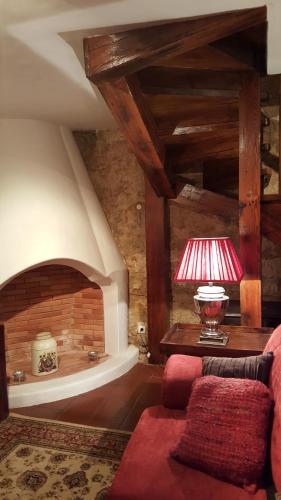 a living room with a red couch and a red lamp at Casa do Castelo - Óbidos in Óbidos