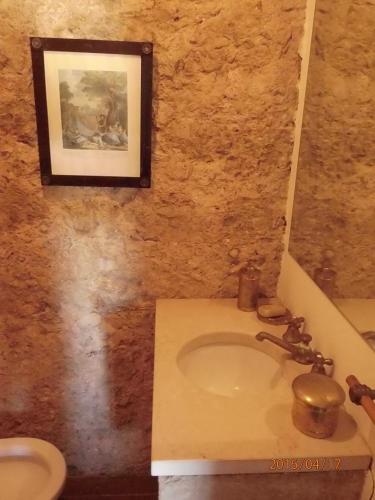 a bathroom with a sink and a picture on the wall at Casa do Castelo - Óbidos in Óbidos