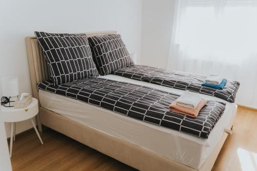 a bed with black and white sheets and towels on it at Stan Brana in Ruma