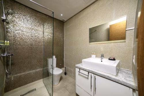 a bathroom with a sink and a toilet and a shower at Grand Standing 110m2 Piscine Terrasse Proche Plage in Agadir
