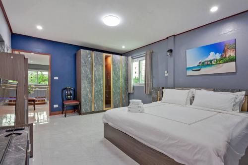 a bedroom with a large bed with a blue wall at Large Spacious 3BR House at BTS ON NUT in Phra Khanong