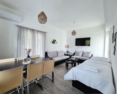 a living room with a bed and a dining room at Mentis Home in Artemida