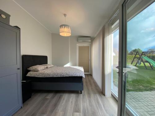 a bedroom with a bed and a large window at Hoovimaja in Pärnu