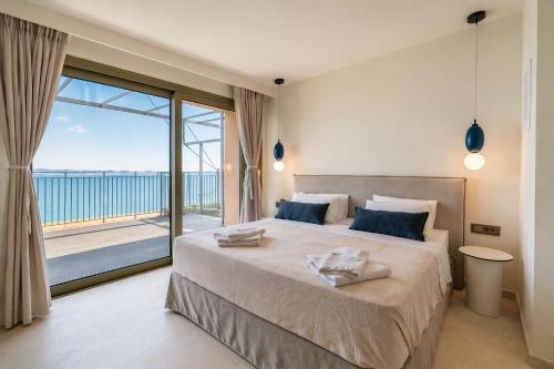 a bedroom with a large bed and a large window at Lorraine's Boutique Suites in Lourdata