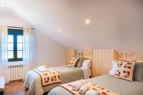 a bedroom with two beds and a window at Casa Xardín in O Pedrouzo