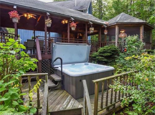 a hot tub on a deck next to a house at Shimmering Cove Retreat in Naples
