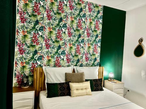 a bedroom with a bed with a floral wallpaper at Spacieux et lumineux Appartement T3 Cayenne in Cayenne