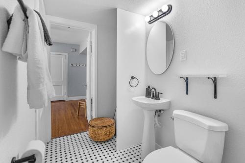 a white bathroom with a toilet and a sink at Natural Sabbatical 1 Bedroom Apartment in Dallas
