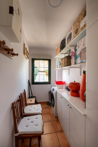 a kitchen with white cabinets and a washing machine at Casa Xardín in O Pedrouzo
