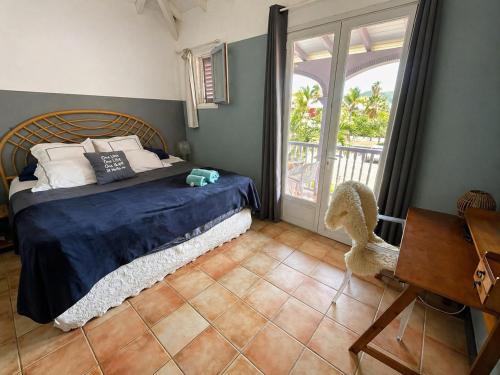 a bedroom with a bed and a table and a window at Kazamwen, maison à Orient bay 2 chambres, piscine résidence et plage à 2 minutes in Orient Bay