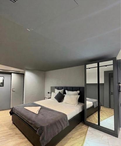 a bedroom with a large bed and a large mirror at Hotel Elion in Yerevan