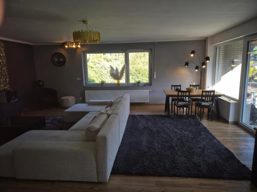 a living room with a white couch and a table at Treuberg Rooms - Cuxhaven Northside in Cuxhaven