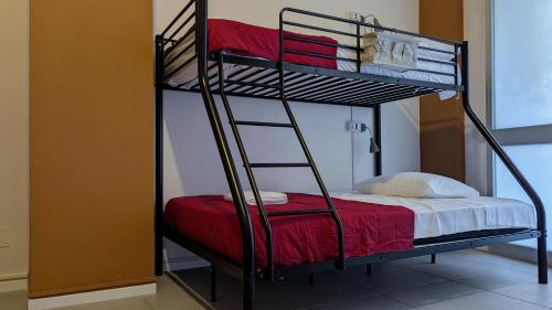 a bunk bed with a ladder next to a room at inScialla Hostel in Trapani