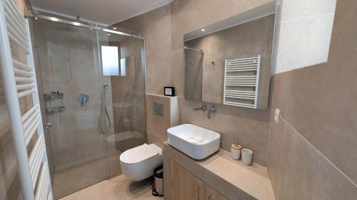 a bathroom with a shower and a toilet and a sink at Villa Levanda in Kiveri