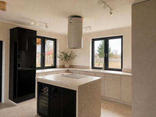 a kitchen with a black and white counter and windows at Pod Skrzydłami II in Liksajny