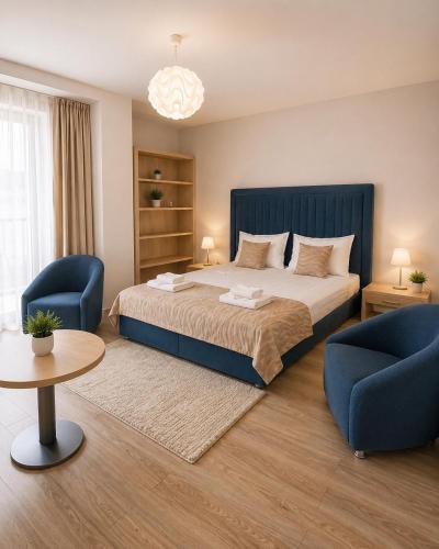 a bedroom with a bed and two chairs and a table at HF - Mamaia Nord in Mamaia Sat/Năvodari