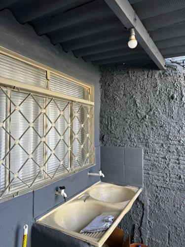 a bathroom with a sink and a window at Casa Aconchego 2, Self Check-in in Presidente Prudente