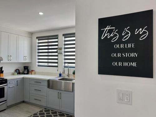 a kitchen with a sink and a sign on the wall at House Ayala 2BR 2Bd in Rosarito