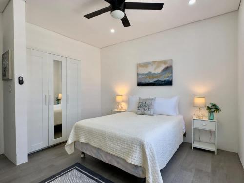 a white bedroom with a bed and a ceiling fan at House Ayala 2BR 2Bd in Rosarito