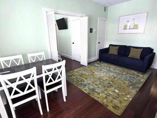 a living room with a blue couch and a table at Duval Street Suite with pool in Key West