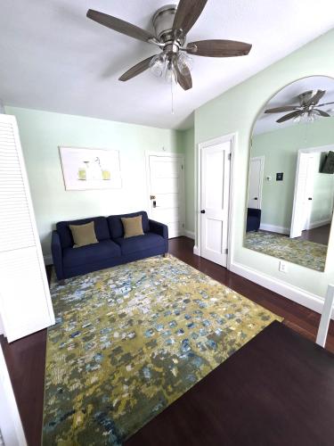 a living room with a blue couch and a mirror at Duval Street Suite with pool in Key West